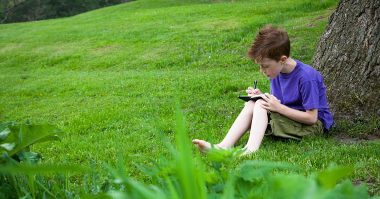 Scout writing at camp