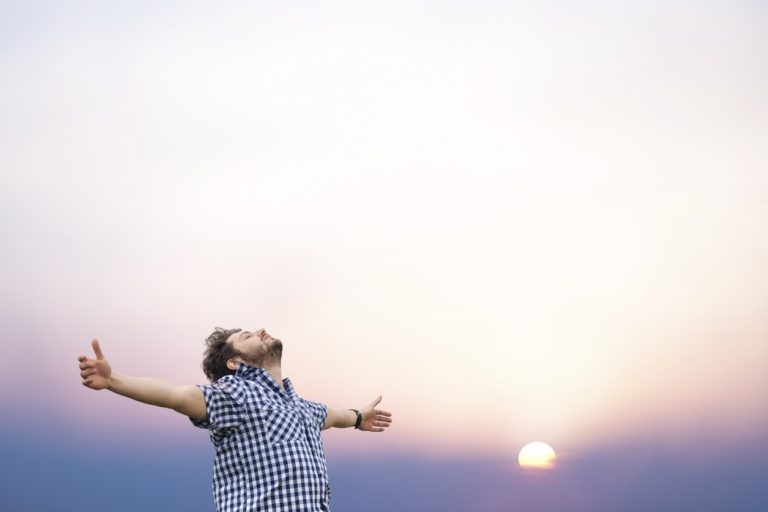 Young man with arms raised