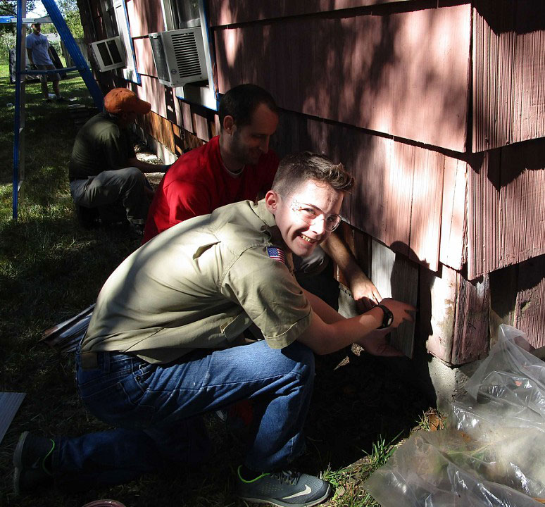 Crew leader Trevor Mangum replaces rotten shingles.