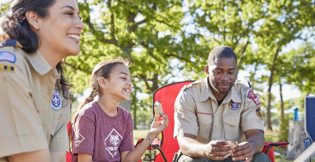 Cub Scout and leaders having s’mores