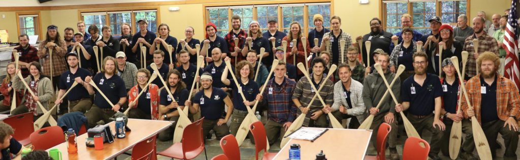 Northern Tier alumni holding paddles