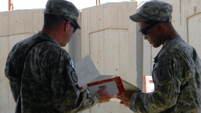Soldiers looking at greeting card