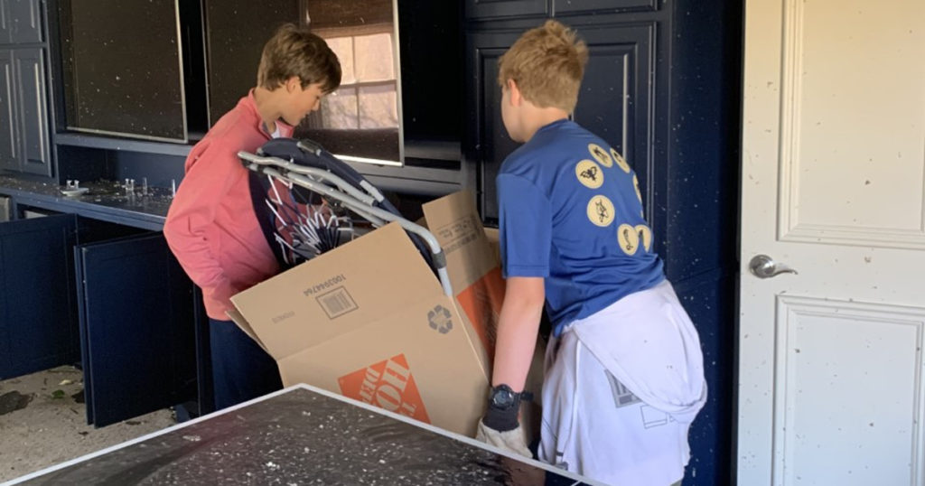Slaton (left) and Oliver carry a box out of Slaton's house.