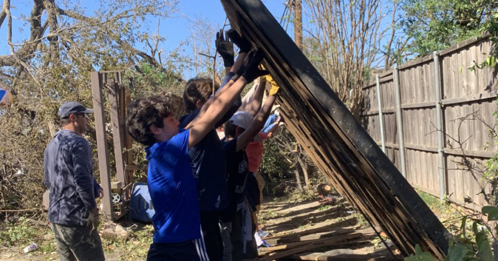 Troop 577 Scouts move a piece of fence blocking an alley.