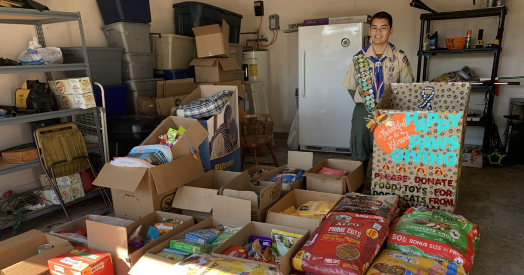 Nicolas stands with the donations