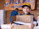 Cub Scout holding care package.