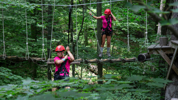 Venturers climb through the trees at the Summit Bechtel Reserve.