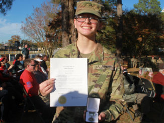 Shannon holds the Summit Award certificate and medal.