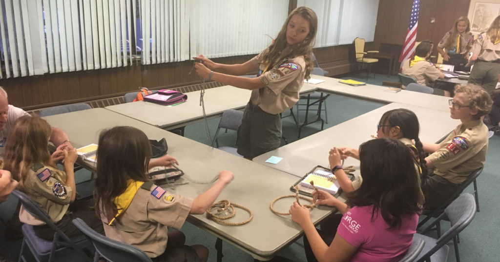 Charlotte teaches Webelos Scouts how to tie a knot