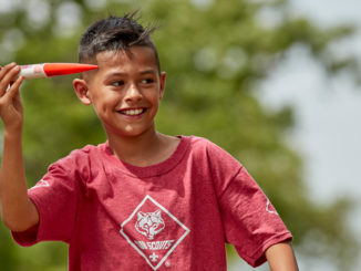 Male Cub Scout holds model rocket
