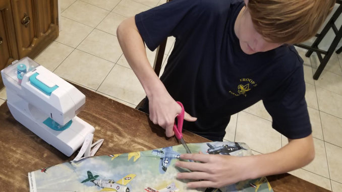 Rafe Kotalik of Troop 777 in the Woodlands, Texas (Sam Houston Area Council), makes face coverings to donate.