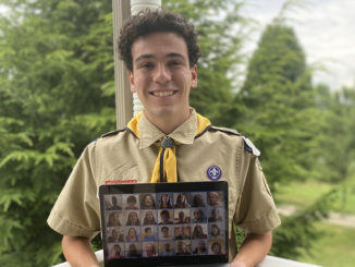 Alex holding his laptop