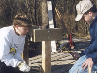 Two Scouts hammer in boards.