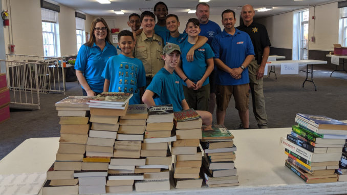 Austin (seated, middle) and his team pose for a photo after sorting books for his Eagle project, in a photo taken in September 2019.
