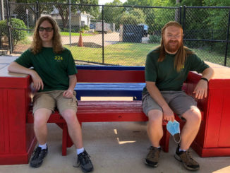 Ethan and Michael sit on benches.