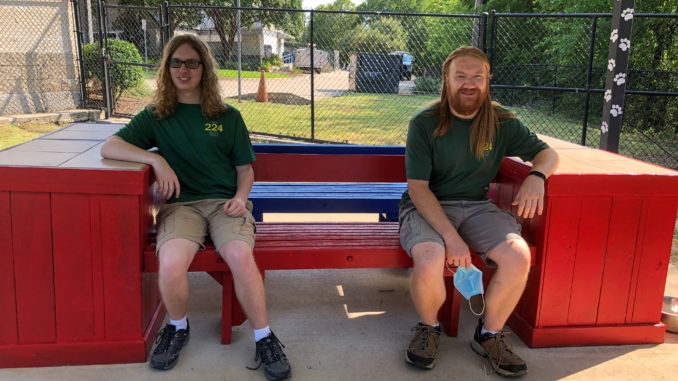 Ethan and Michael sit on benches.
