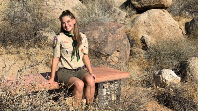 Victoria sits on the bench she built for her Eagle project