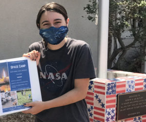 Ani holds a binder containing the plans for her space camp.