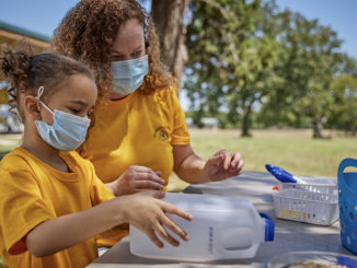 A Cub Scout and her mom work on a birdfeeder.