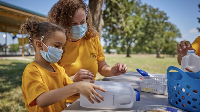 A Cub Scout and her mom work on a birdfeeder.