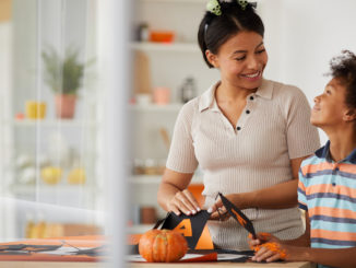 A mom and son decorate for Halloween