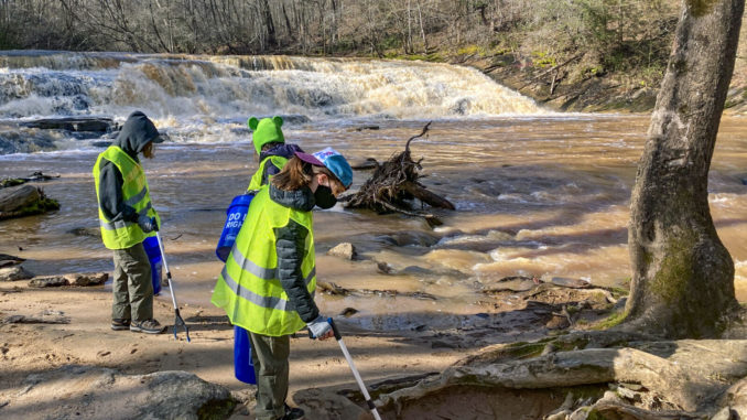 A picture of a Scout picking up trash at camp