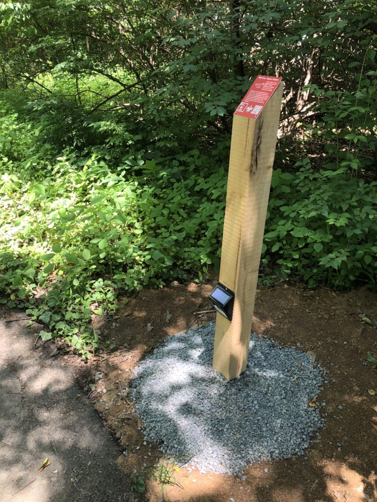 A wooden post with a red sign.