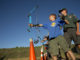 Scout camp staffer helps camper with archery at summer camp