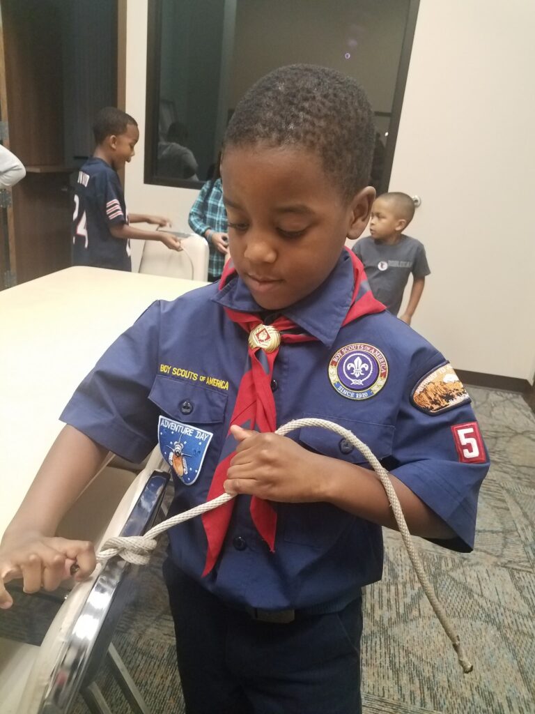 A Cub Scout from Pack 53 practices his knot-tying skills