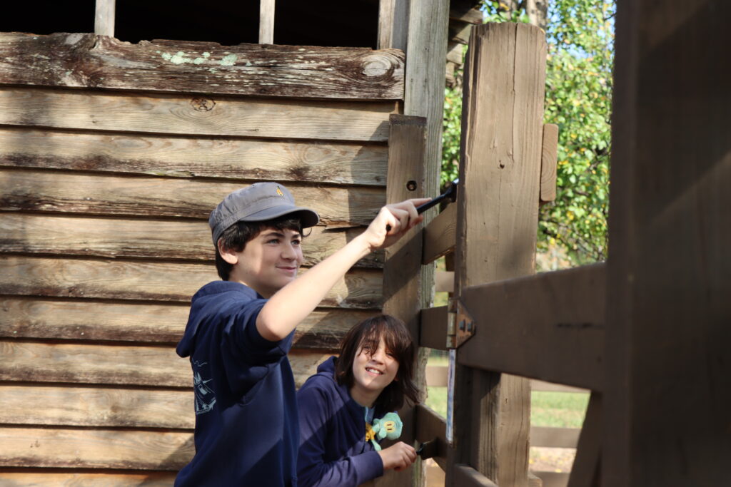 Scouts painting a fence
