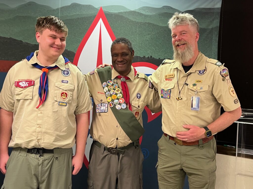 Darrell White stands between his Scoutmaster and a youth member of Troop 77