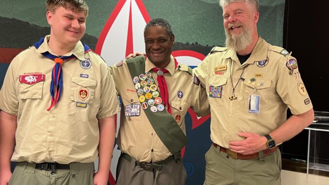 Darrell White stands between his Scoutmaster and a youth member of Troop 77