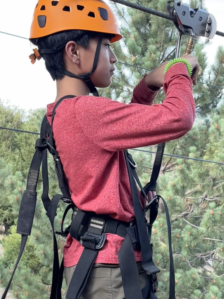 12-year-old college graduate Clovis Hung prepares to ride on a zip line
