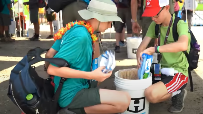Scouts put supplies into a flood bucket