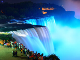 A photo of Niagara Falls illuminated at night