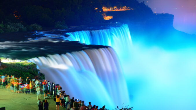 A photo of Niagara Falls illuminated at night