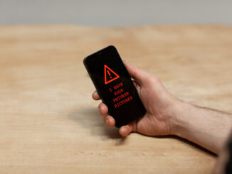 A photo of phone with a screen that shows that their photos have been compromised