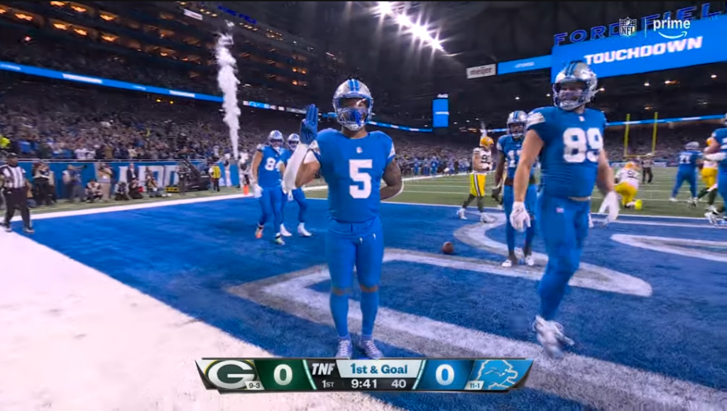 A screen capture of David Montgomery flashing the Scout salute after scoring a touchdown