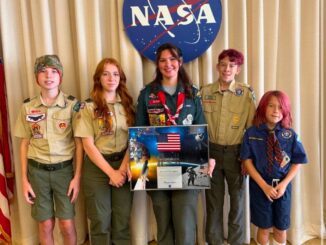 A photo of Scouts in front of the official NASA emblem