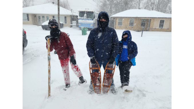 A photo of three Scouts bundled up during a snowstorm