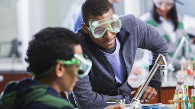 A photo of Scouts BSA-aged youth working on a chemistry experiment