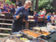 A photo of an Upper Crust Food Service chef preparing a meal for a group of campers
