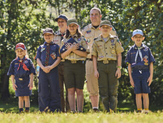 A photo of a group of Cub Scouts performing a flag ceremony while wearing their uniforms