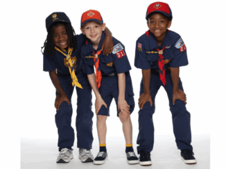 A photo of three Cub Scouts, each of whom are very excited to join Scouting