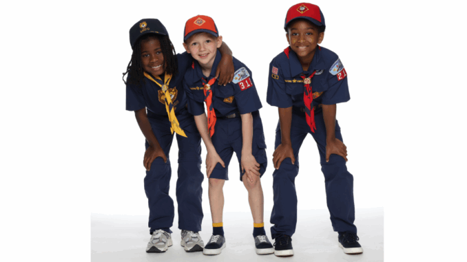 A photo of three Cub Scouts, each of whom are very excited to join Scouting
