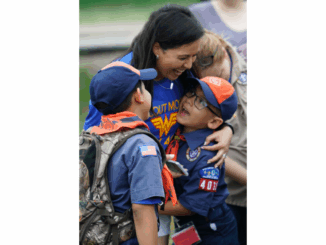 A photo of a Cub Scout mom hugging her Cub Scout children