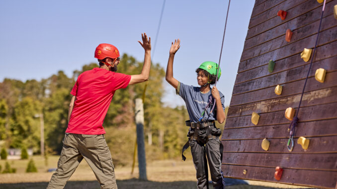 high-five at the climbing wall - Scouts BSA photo 2024