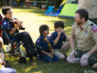 Wolf Cub Scouts at a pack meeting outside with a scout in a wheelchair