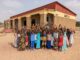 A group of children stand in front of the finished school in Ndioudiouf, Senegal
